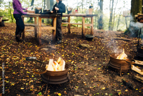 Two fire pits in forest and people camping photo