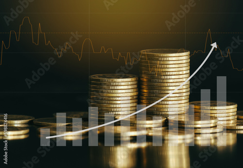 Stack of golden money coin on office desk with growth arrow and graph. Business and financial concept background. 