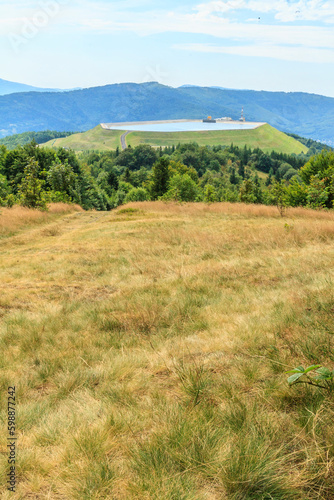 View from Kiczera on a sunny summer day at the artificial reservoir of the pumped-storage power plant on the Żar mountain in the Silesian Beskids, Poland. © IwoiWo