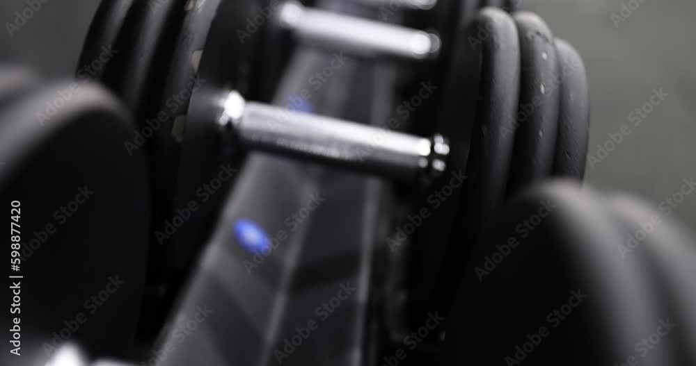 Lot of dumbbells lying neatly in row in gym closeup 4k movie slow motion. Sports training concept Lot of dumbbells lying neatly in row in gym closeup 4k movie slow motion. Sports training concept
