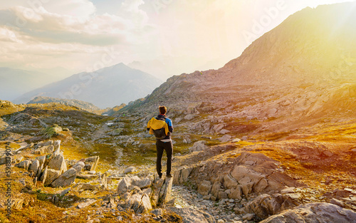 Hiker walks with backpack in sunset mountains. Lifestyle vacation hiking outdoor. Discovery Travel Destination Concept photo