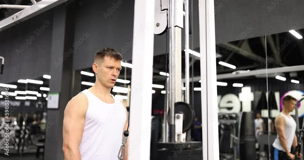 Man training with help of flex on sports simulator in gym 4k movie slow motion. Fitness and healthy lifestyle concept Man training with help of flex on sports simulator in gym 4k movie slow motion. Fitness and healthy lifestyle concept