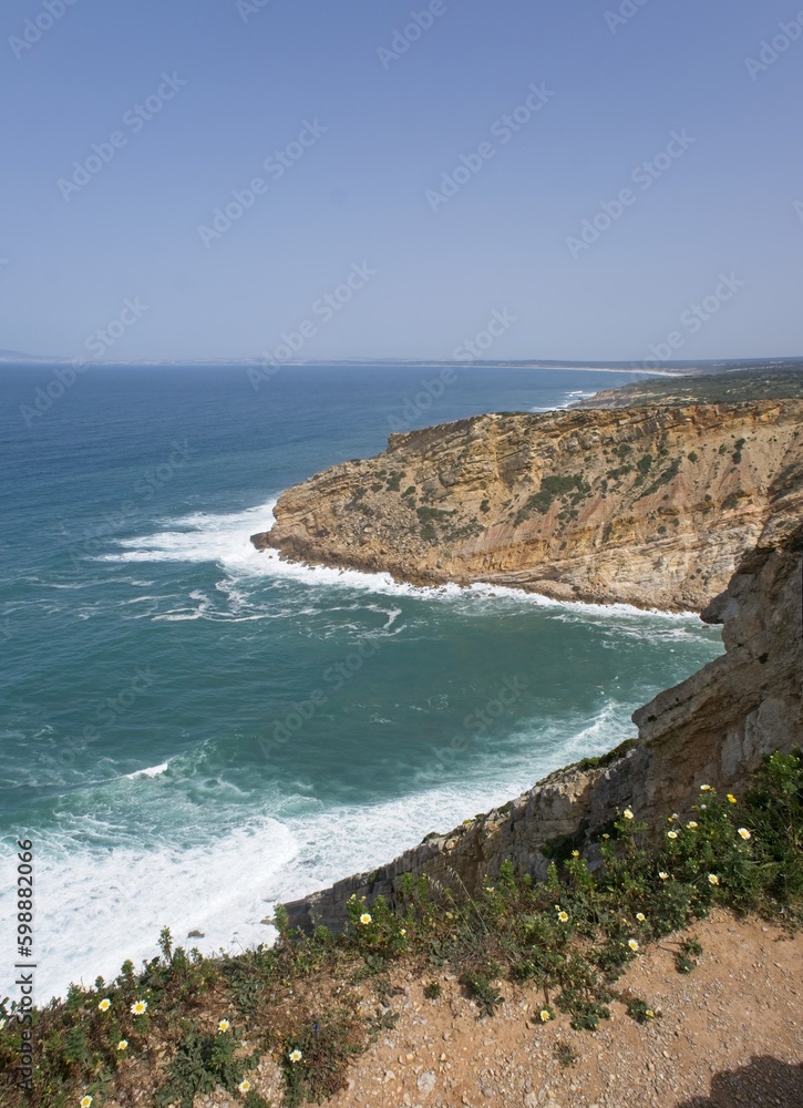 Wonderful landscapes in Portugal. Scenic coastline in Sesimbra. Lagosteiros Natural Monument from the cliff. Wavy sea. Rocky skerries. Sunny spring day. Selective focus