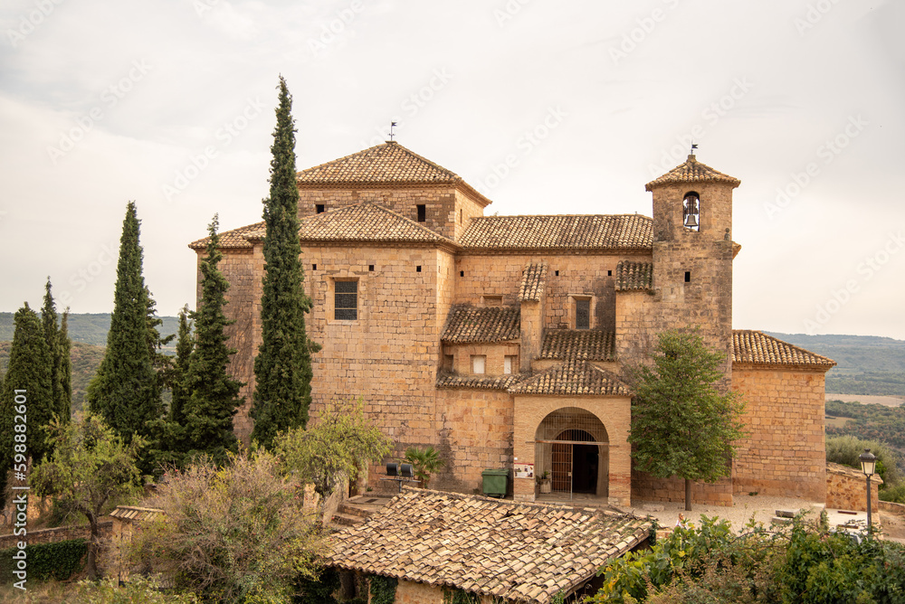 Church of Santa María la Mayor, from medieval times and built in brick in the tourist village of Alquezar in Huesca during a cloudy day.