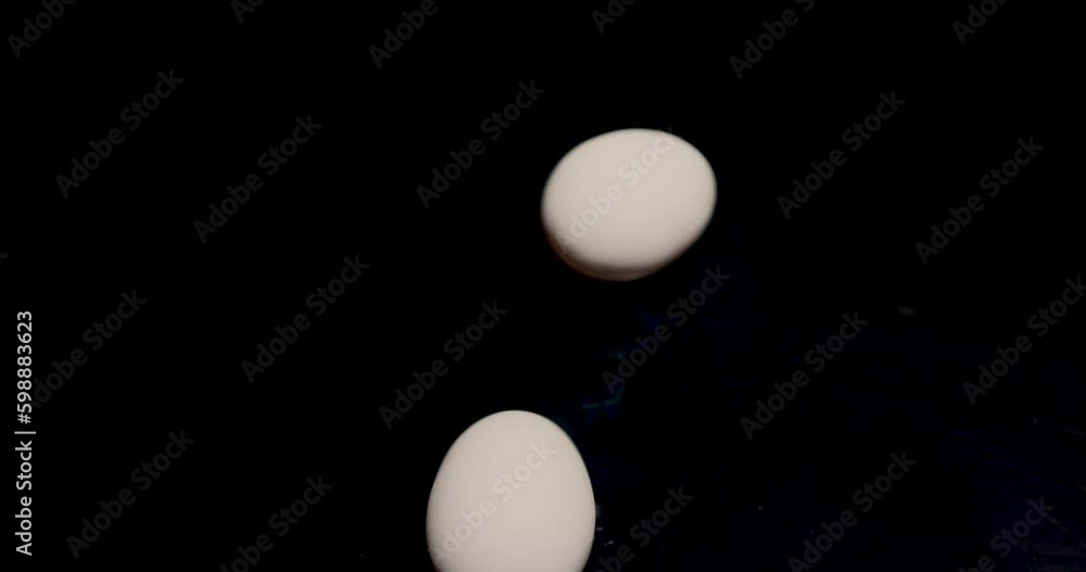 Two chicken egg whites spinning on a black background. Ingredients for cooking. Egg white and yolk. Two eggs for Easter holiday. Animal protein is beneficial. Two chicken egg whites spinning on a black background. Ingredients for cooking. Egg white and yolk. Two eggs for Easter holiday. Animal protein is beneficial.