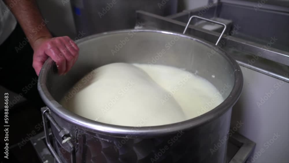Pouring hot rennet water over cheese Pouring hot rennet water over cheese