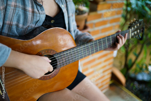 Happy young Woman hands playing acoustic guitar musician  alone compose instrumental song lesson on playing the guitar