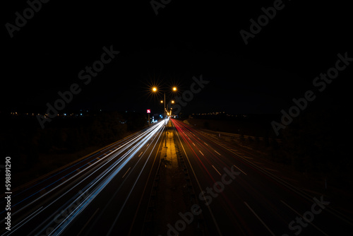Flowing traffic and lengthening lights of vehicles on the highway at night. Long exposure 