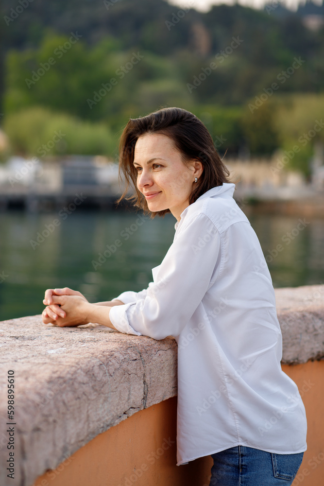 The portrait of brunette caucasian woman enjoying vacations at the Italian Garda lake The portrait of brunette caucasian woman enjoying vacations at the Italian Garda lake
