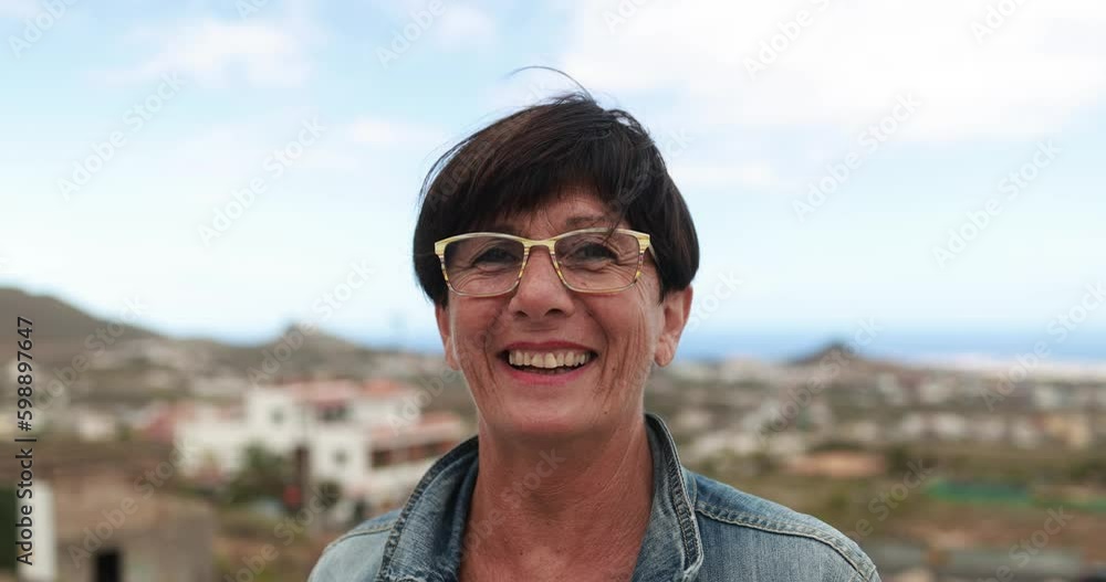 Senior woman smiling on camera at house rooftop outdoor Senior woman smiling on camera at house rooftop outdoor