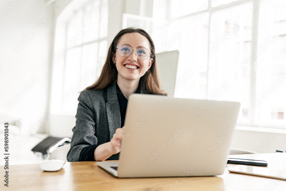 A woman smiles at a creative person in formal clothes on the Internet, using a laptop. Good education and training online on the school's website and app. A woman smiles at a creative person in formal clothes on the Internet, using a laptop. Good education and training online on the school's website and app.