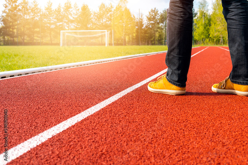 Man standing on the empty stadium with football gate and running track photo