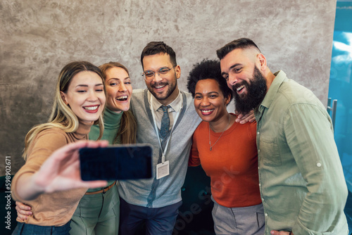 Fotografiet Happy group of coworkers taking a selfie at the office