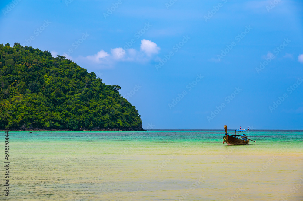 Landscape view of coastline with limestone rock and boats on ocean at Ko Phi Phi islands, Thailand. Concept of exotic tropical vacation and beautiful nature in paradise Landscape view of coastline with limestone rock and boats on ocean at Ko Phi Phi islands, Thailand. Concept of exotic tropical vacation and beautiful nature in paradise