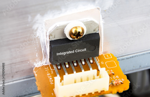 Close up macro of IC integrated circuit attached to aluminum heat sink on electronic circuit board. concept of electronic components photo