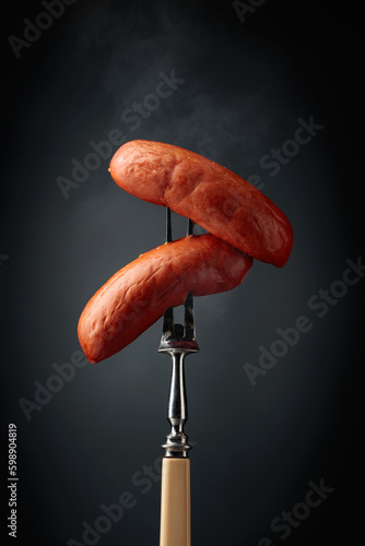 Boiled sausages on a fork.