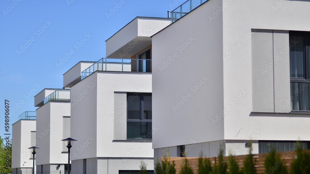 Terraced family homes in newly developed housing estate. The real estate market in the suburbs. New single family houses in a new development area. Residential homes with modern facade. 