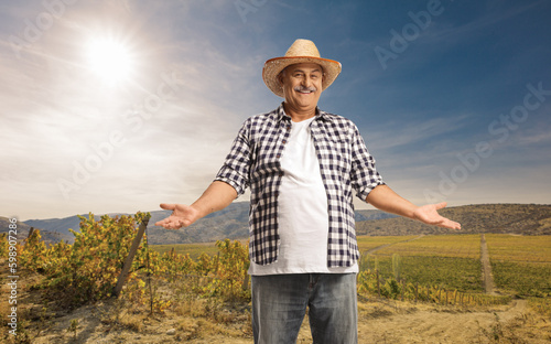 Happy mature farmer standing on a field