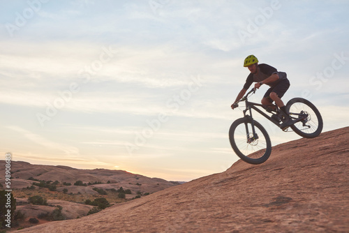 Find your own adventure and ride on. a young man out mountain biking during the day.
