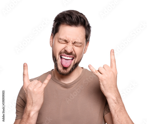 Happy man showing his tongue and making rock gesture on white background