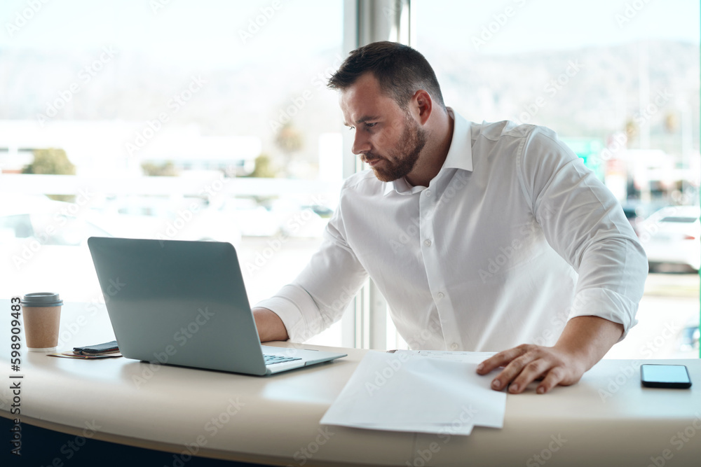 Having the correct paperwork matters. a young car salesman filling out paperwork in his office. Having the correct paperwork matters. a young car salesman filling out paperwork in his office.