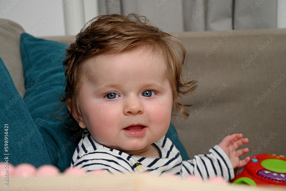 Naklejka premium smiling newborn baby sitting on sofa