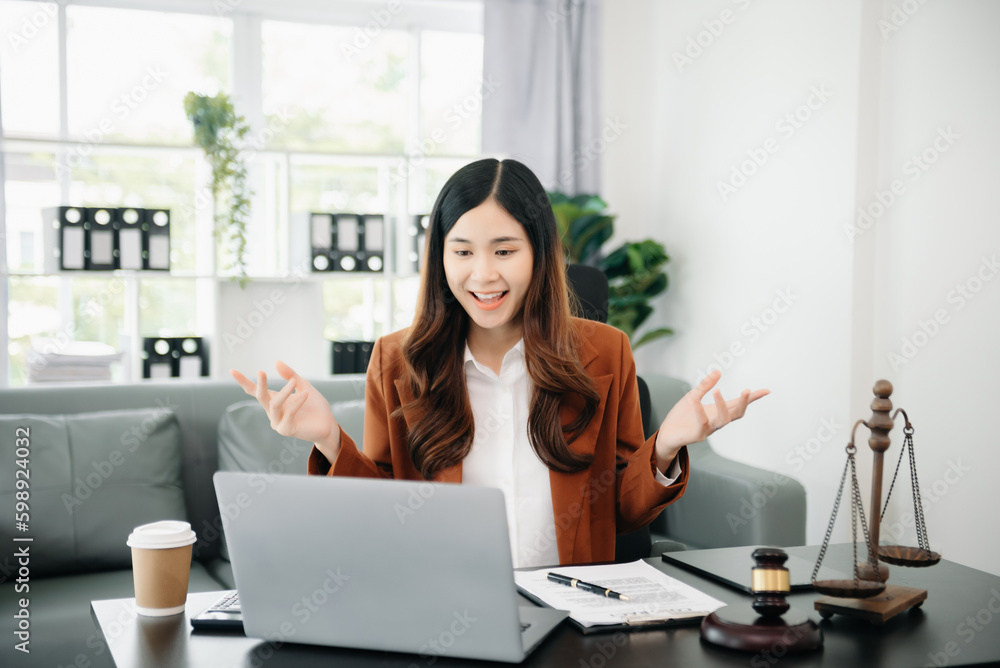 Asian female lawyer chatting online with client on laptop, smartphone discussing details of lawsuit. in office. Asian female lawyer chatting online with client on laptop, smartphone discussing details of lawsuit. in office.