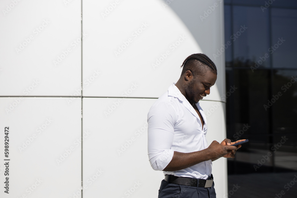 portrait of handsome african man in white shirt with mobile phone portrait of handsome african man in white shirt with mobile phone