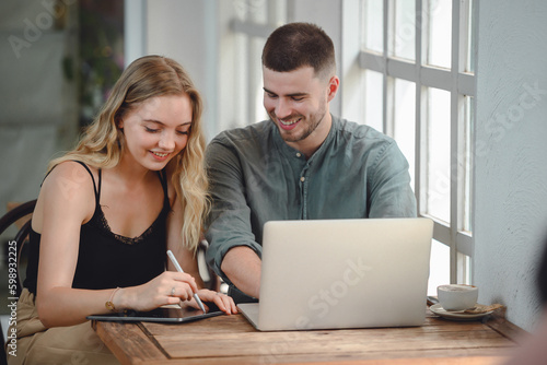 Girl and young man with casual lifestyle working on laptop computer in her studio. Two Caucasian Couples Sitting Outside Workplace