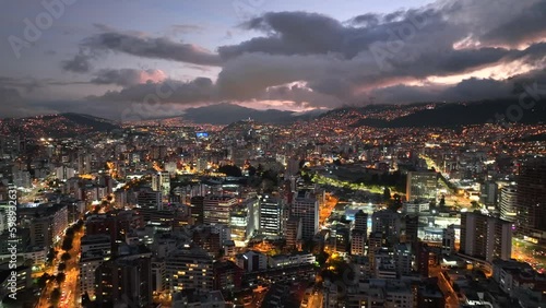 Aerial drone footage of Quito, Ecuador at night with the city lights on just after sunset photo
