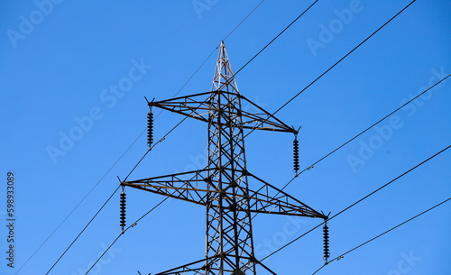 A power line tower with a blue sky in the background
