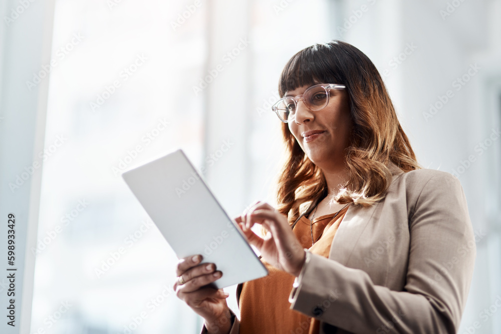 Finding a niche online. an attractive young businesswoman using a digital tablet in her office. Finding a niche online. an attractive young businesswoman using a digital tablet in her office.