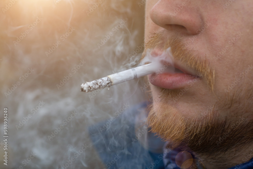 Close up portrait of young man smoking cigarette - obrazy, fototapety, plakaty 