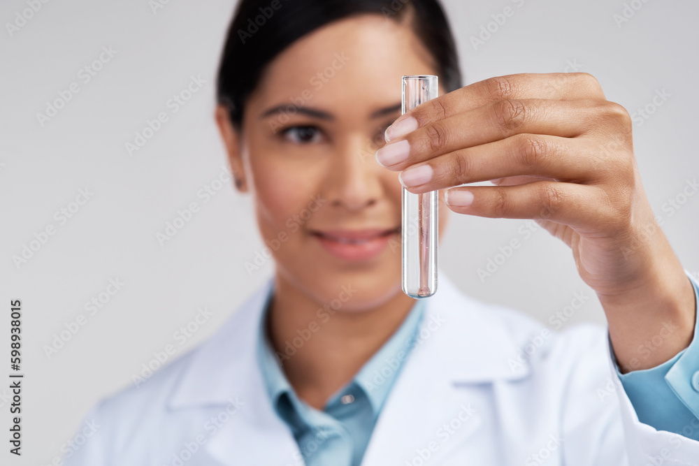 Lets see whats gonna happen. an attractive young female scientist examining a vial filled with liquid in studio against a grey background. Lets see whats gonna happen. an attractive young female scientist examining a vial filled with liquid in studio against a grey background.