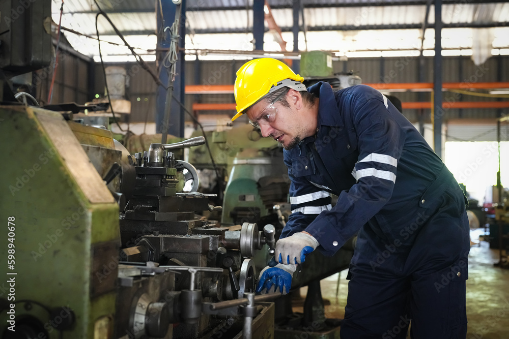 Lathe Operators Concentrated on Work. Worker in uniform and helmet works on lathe, factory. Industrial production, metalwork engineering, manufacturing.