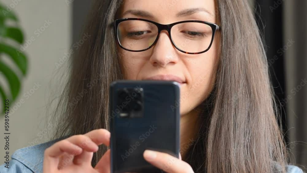 close-up woman smiling looking at her smartphone and checking her messengers close-up woman smiling looking at her smartphone and checking her messengers