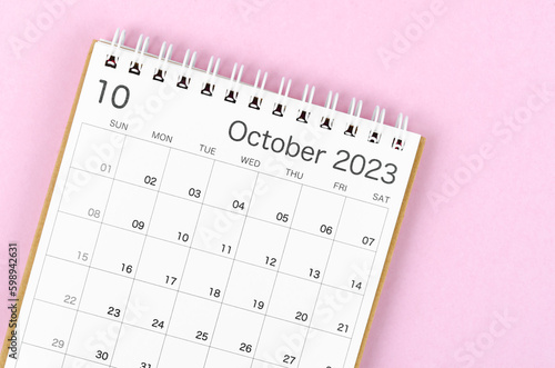 A October 2023 calendar desk for the organizer to plan and reminder isolated on pink background.