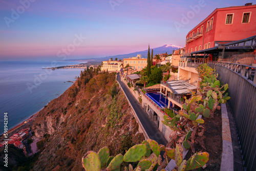Obraz na płótnie Taormina, Sicily, Italy. Cityscape image of picturesque town of Taormina, Sicily with volcano Mt. Etna in the background at sunrise. w salonie