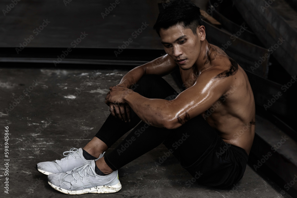 Fitness man sit relax after exercise training warm up body and posing in gym, Healthy lifestyle.