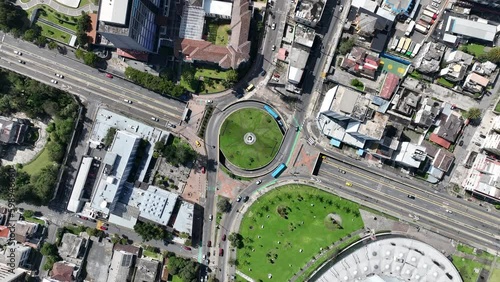 Cars driving through traffic circle in city in South America. Aerial top down drone view of traffic in large intersection in Quito, Ecuador.
