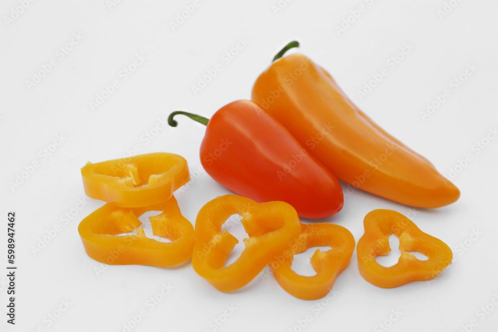 Cut and whole orange hot chili peppers on white background Cut and whole orange hot chili peppers on white background