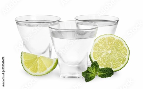 Shot glasses of vodka with lime and mint on white background © New Africa