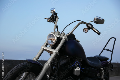 Modern black motorcycle against blue sky outdoors