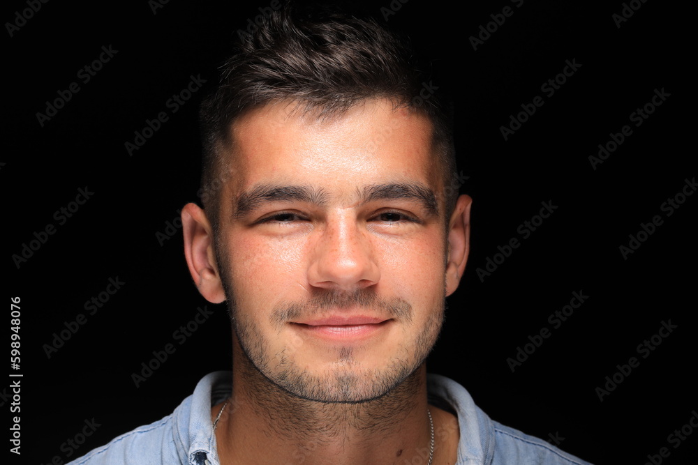 close-up portrait of a handsome man smiling on a black background. a man of model appearance. close-up portrait of a handsome man smiling on a black background. a man of model appearance.