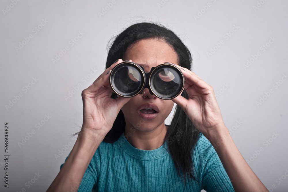 portrait of young woman while looking through binoculars portrait of young woman while looking through binoculars