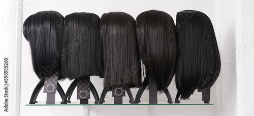 Obraz na plátně Showcase of natural looking wigs in different haircut options fixed on the wig holders in beauty salon
