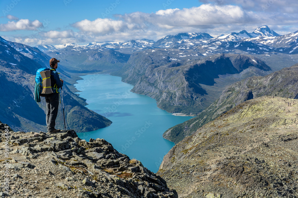 Wanderer auf dem Besseggen Grat mit Blick auf Gjende See, Jotunheimen Nationalpark, Norwegen