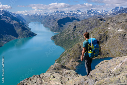 Wanderer auf dem Besseggen Grat mit Blick auf Gjende See, Jotunheimen Nationalpark, Norwegen