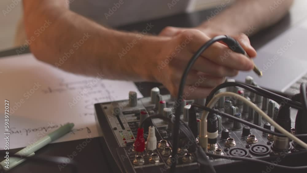 Cropped shot of unrecognizable male radio host operating broadcast console at workplace