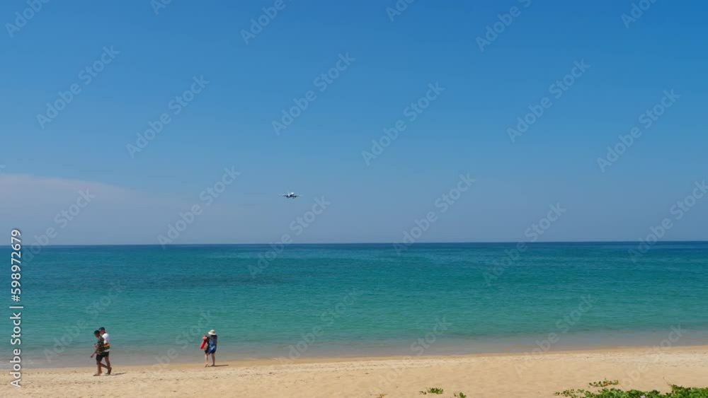 Airplane approaching to land over the blue sea. People taking pictures of an airplane on the beach. Tourism and travel concept Generative AI Airplane approaching to land over the blue sea. People taking pictures of an airplane on the beach. Tourism and travel concept Generative AI